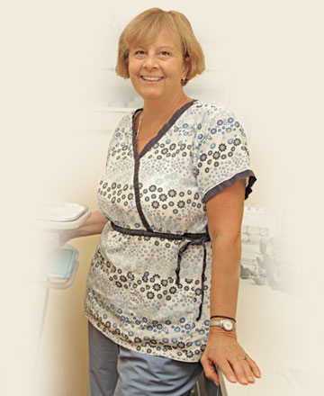 Staff member of Dr. Tartaglione standing by her dental equipment